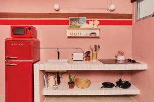 a small kitchen with a red refrigerator and a counter at MOOD HAUS by DW in San Juan