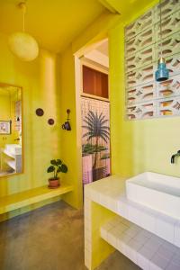 a yellow bathroom with a sink and a mirror at MOOD HAUS by DW in San Juan