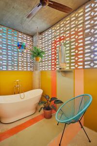 a bathroom with a tub and a chair at MOOD HAUS by DW in San Juan