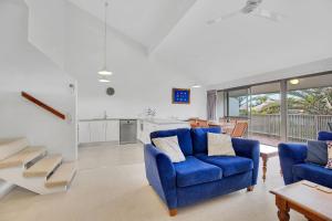 un soggiorno con due sedie blu e un tavolo di 19 Peregian Court Resort a Peregian Beach