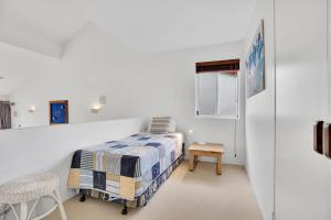 una camera da letto bianca con un letto e un tavolo di 19 Peregian Court Resort a Peregian Beach