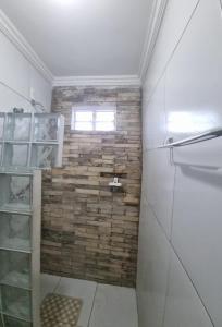 baño con ducha y pared de ladrillo en Pé na Areia, en Itapipoca