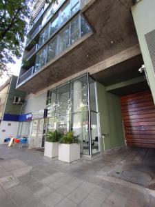 um edifício com portas de vidro e plantas à sua frente em ARKA Classy Apartments em Buenos Aires