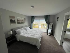 ein Schlafzimmer mit einem weißen Bett und einem Fenster in der Unterkunft Ocean View Oasis in Campbell River