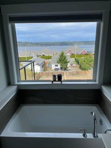 una ventana sobre un lavabo blanco en el baño en Ocean View Oasis en Campbell River