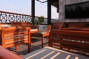 un restaurante con sillas de madera y TV de pantalla plana en The Lu'um House en Tuxtla Gutiérrez