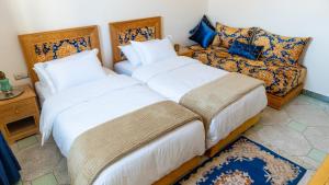 a bedroom with two beds and a couch at Dar Bouzoubaa in Fez