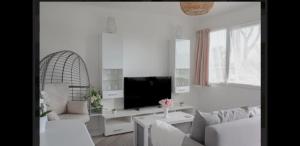ein Wohnzimmer mit weißen Möbeln und einem Flachbild-TV in der Unterkunft Seadell 2 Bed Coastal Chalet in Hemsby Great Yar in Hemsby