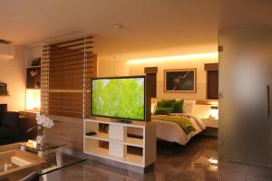 a living room with a television and a bed at The Lu'um House in Tuxtla Gutiérrez