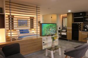sala de estar con TV de pantalla plana en una habitación en The Lu'um House en Tuxtla Gutiérrez