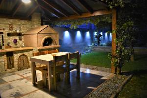 a table and chairs in a backyard with a outdoor oven at My Paradise in Asíni