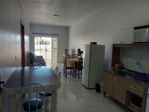 a kitchen and dining room with a table and a refrigerator at Residencial Baldissera e Zeni in Machadinho