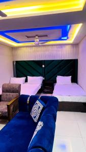 um quarto com duas camas e um sofá em Hotel 11 em Islamabad