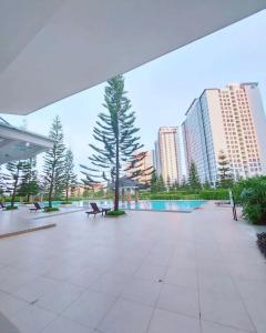 une terrasse avec bancs, arbres et grands bâtiments dans l'établissement The Penn Room Tagaytay at Cool Suites, à Tagaytay