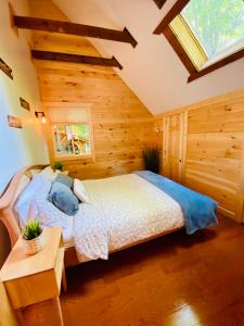 Lake ArielにあるLakeview Cabin in The Hideoutの木製の部屋にベッド1台が備わるベッドルーム1室があります。