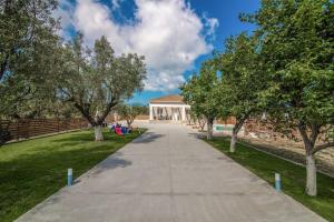 a sidewalk in front of a house with trees at Villa Saliaj in Ambelókipoi