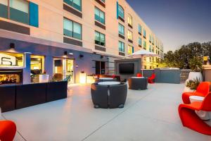 a building with a patio with furniture and a tv at Aloft Columbia Harbison in Columbia