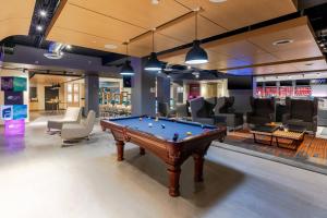 a pool table in the middle of a gaming room at Aloft Columbia Harbison in Columbia