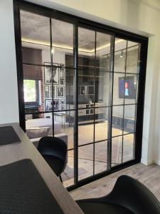 a room with a large glass window with a table and chairs at ART STUDIO BNB in Craiova
