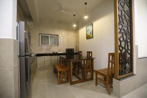 a kitchen with a table and chairs and a refrigerator at VIPRA HOTEL in Coimbatore