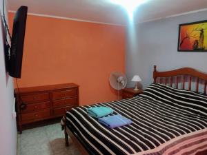 a bedroom with a black and white bed and a dresser at Casa Rojas Malargüe in Malargüe