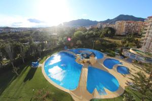 widok na duży basen w parku w obiekcie Jupiter. Moderno estudio. Vistas al mar y montaña w mieście Benalmádena