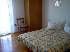 1 dormitorio con 1 cama, 1 silla y 1 ventana en Apartment Karmen, en Trogir