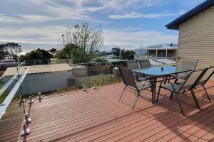 a patio with a table and chairs on a deck at A Hidden Tranquil Gem on Douglas in Bicheno