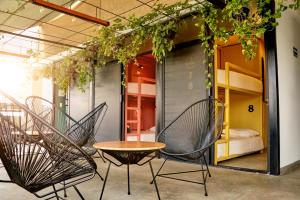 - une chambre avec deux chaises, une table et un lit dans l'établissement Casa Nomada Hotel - Hostal, à Tuxtla Gutiérrez