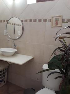 een badkamer met een toilet en een spiegel en een plant bij Bedroom near Forest in Rio de Janeiro