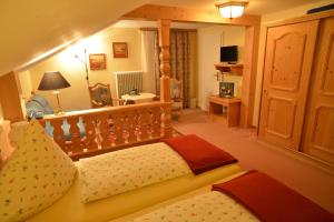 ein Schlafzimmer mit einem Bett und einem TV in einem Zimmer in der Unterkunft Hotel Adlerschanze in Schönwald