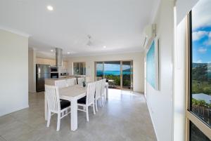 comedor y cocina con mesa y sillas en The Power House - Views & More en Airlie Beach