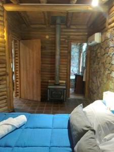 1 dormitorio con cama azul y fogones en Rincón Alto Cabañas en Nono