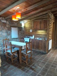 cocina con mesa y sillas en una habitación en Rincón Alto Cabañas en Nono