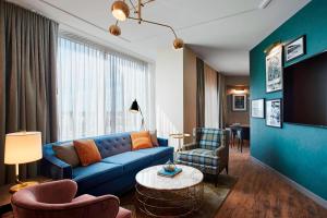 a living room with a blue couch and chairs at Hotel Zachary, Chicago, a Tribute Portfolio Hotel in Chicago