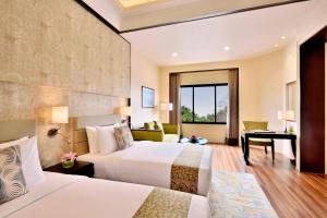 una camera d'albergo con 2 letti e una scrivania di Four Points by Sheraton Srinagar a Srinagar