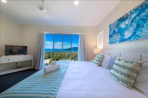 1 dormitorio con 1 cama blanca grande y ventana grande en The Power House - Views & More en Airlie Beach