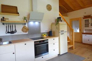 een keuken met witte kasten en een fornuis bij Bleierhof in Kiefersfelden