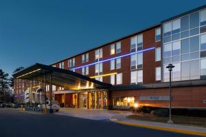 a large brick building with a bus stop in front of it at Aloft Lexington in Lexington