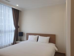 a bedroom with a white bed and a window at Vinhomes Central Park Apartment Landmark Căn hộ DV in Ho Chi Minh City