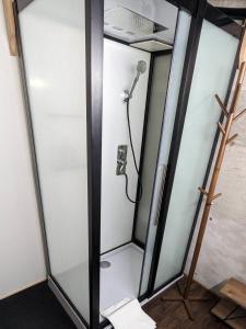 um chuveiro num quarto com uma parede de vidro em The Joint em Hakuba
