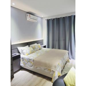 um quarto com uma cama e ar condicionado na parede em Studio Flat Suite Completo 519 em Cotia