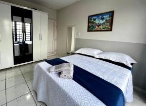 um quarto com uma cama com um cobertor azul e branco em Casa no Centro (Orla de Marabá) em Marabá