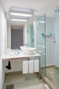 een badkamer met een wastafel en een glazen douche bij Aloft Cancun in Cancun