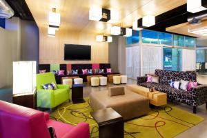 a lobby with colorful furniture and a flat screen tv at Aloft Cancun in Cancún