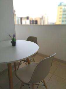 a white table and chairs with a potted plant on it at Flat particular no Hotel Mercure in Brasília