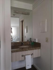 a bathroom with a sink and a mirror at Hotel Lider à 1km da Esplanada dos Ministérios in Brasilia