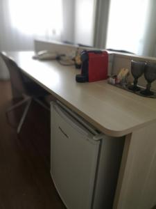 a desk with a counter top with a red appliance at Flat particular no Hotel Mercure in Brasília +5 photos
