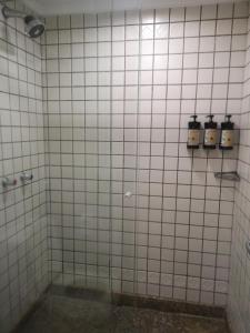 a white tiled shower with two bottles on the wall at Flat particular no Hotel Mercure in Brasília