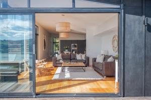 a living room with sliding glass doors leading into a living room at Million Dollar View - Takamatua Holiday Home in Akaroa